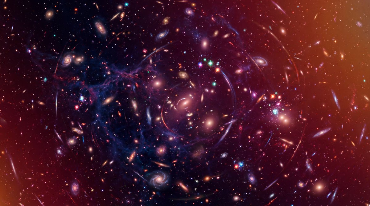 A vast cosmic web of glowing galaxies connected by faint purple filaments against a deep black background of space.