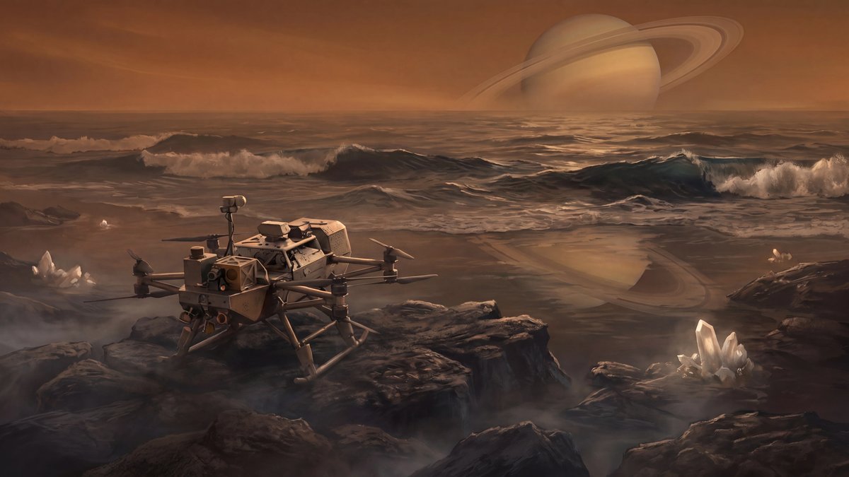 A futuristic lander sits on the alien shoreline of a liquid methane sea under a hazy orange sky with Saturn overhead.