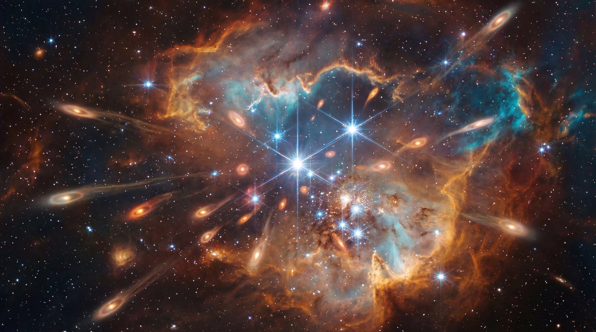 Teardrop-shaped gas disks glowing amidst vibrant orange and blue nebula clouds, illuminated by bright spiky stars.