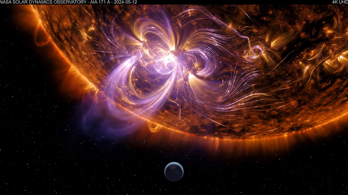 An intense solar flare erupting from the Sun, with Earth shown as a tiny sphere for scale against the vast solar corona.